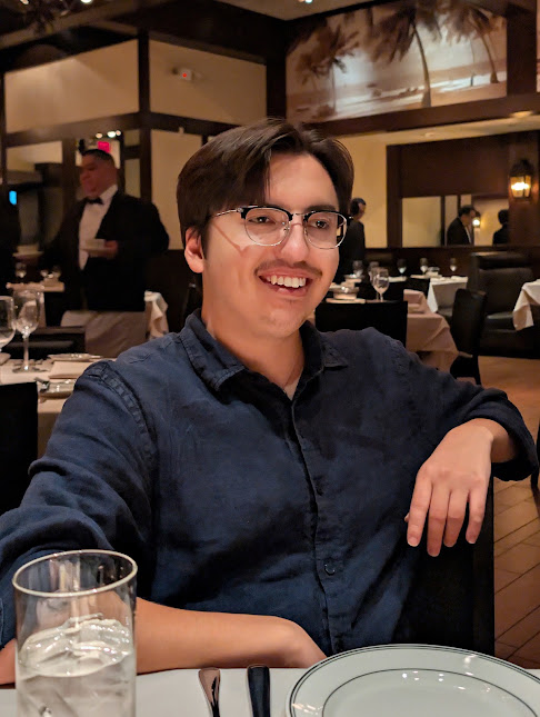 David Krieger laughing mid-conversation at a dinner table